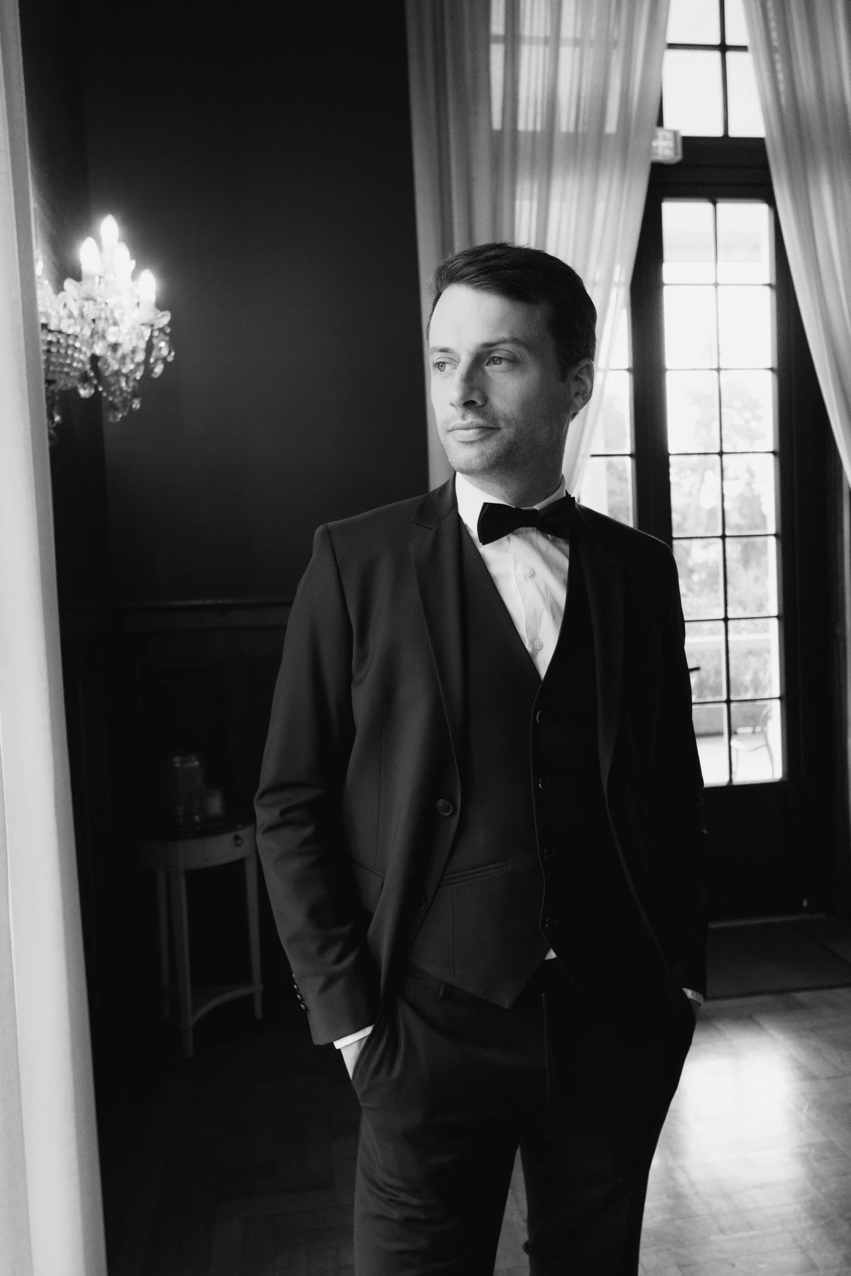 Groom getting ready in castle near window