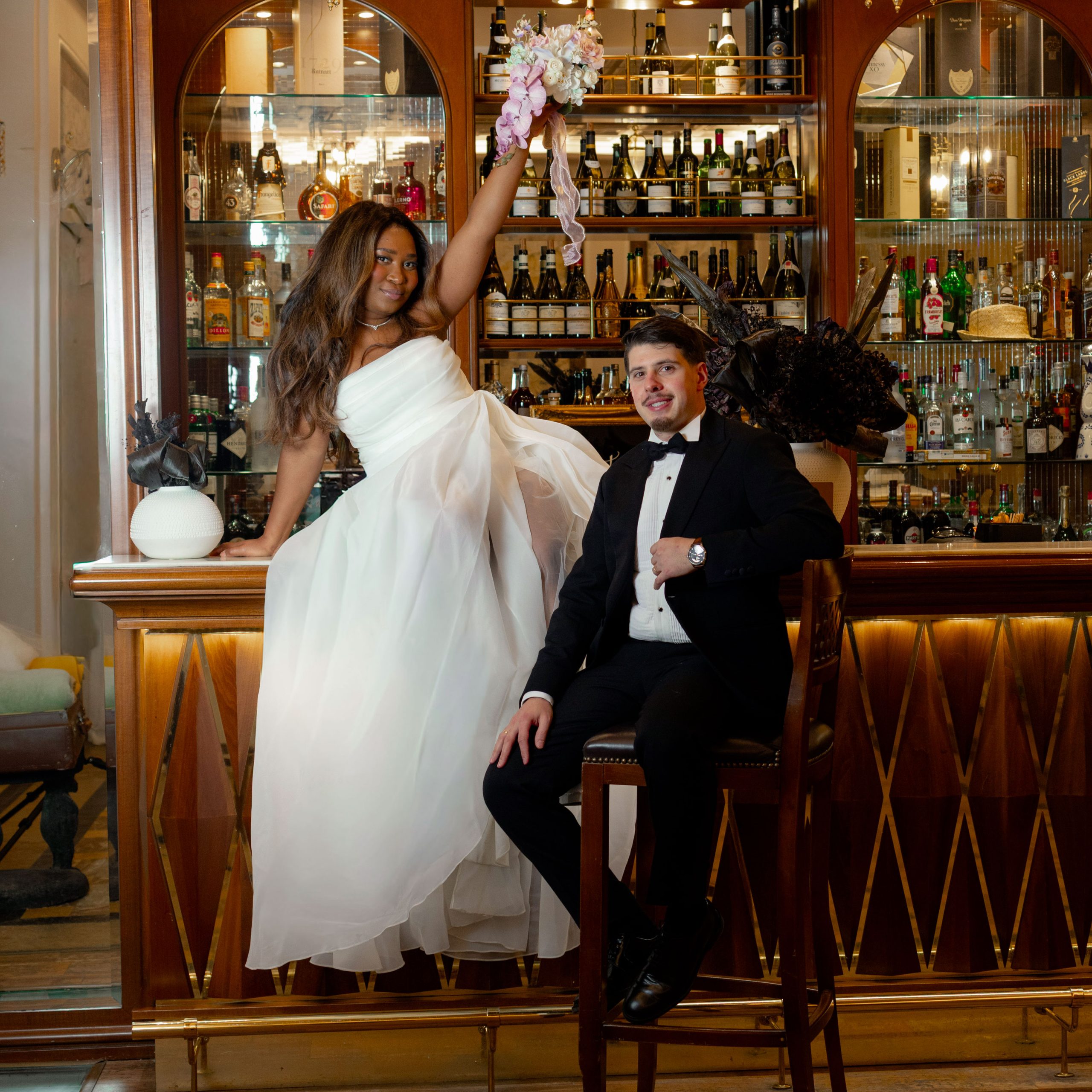 Couple marié élégant assis devant un bar en bois raffiné dans un hôtel de luxe